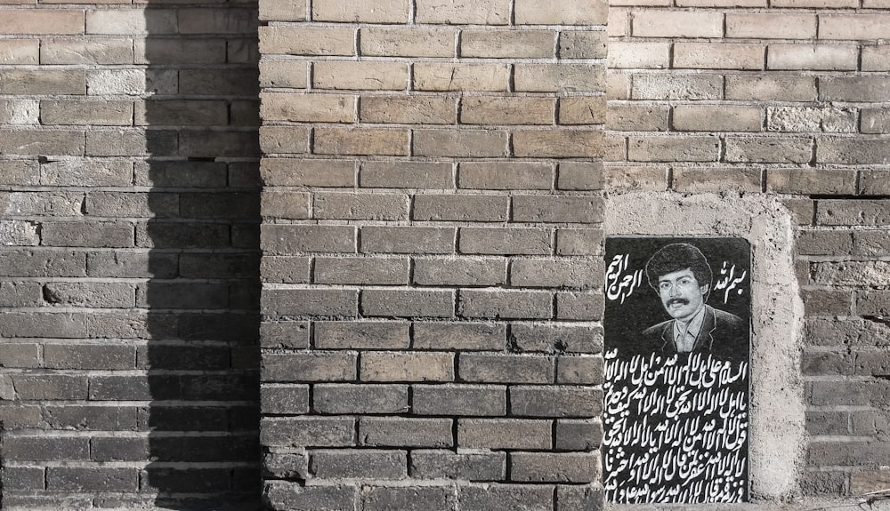 una pared de ladrillo con una imagen de un hombre en ella