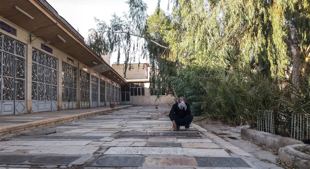 a woman walking down a street next to a building