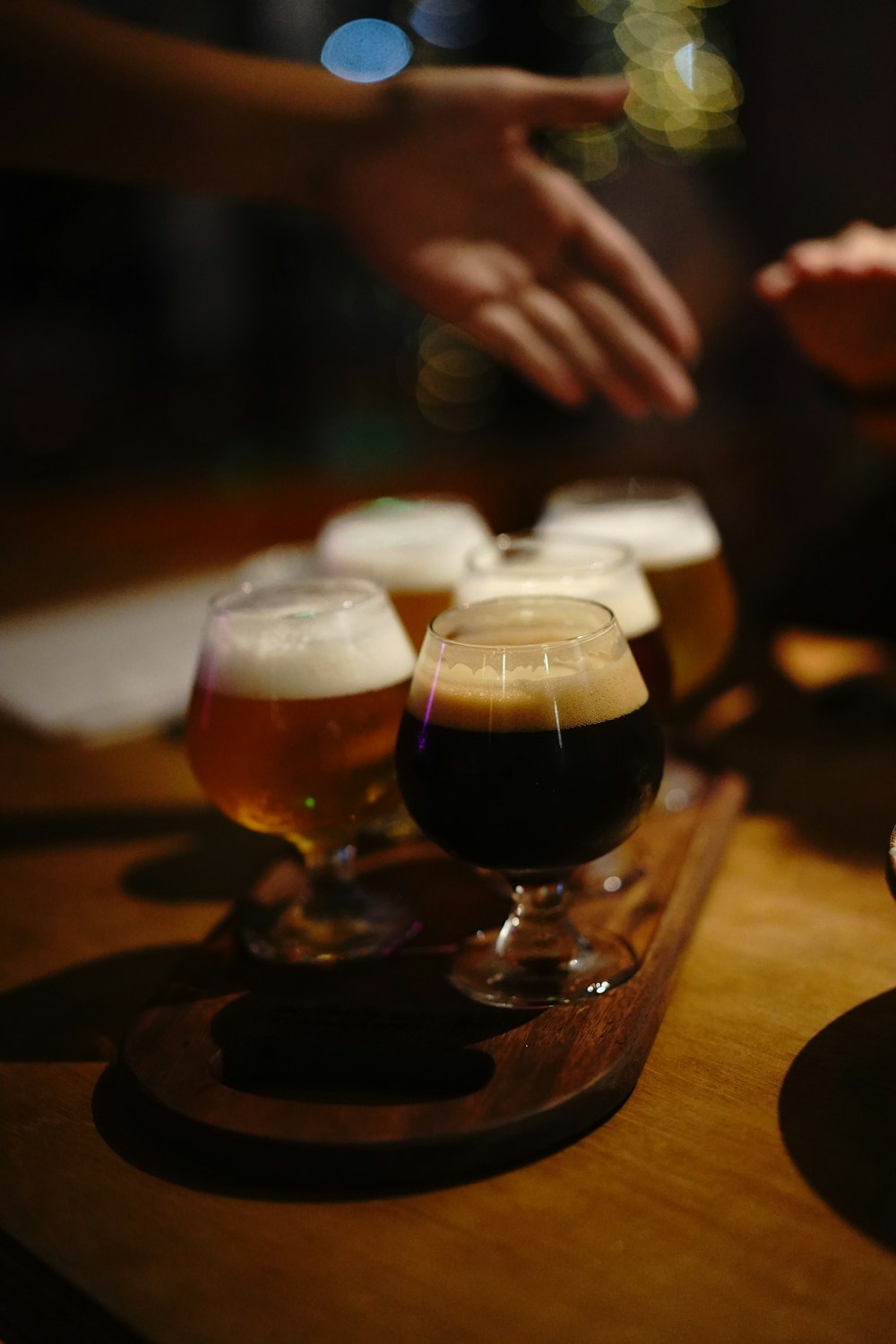 a wooden table topped with glasses of beer