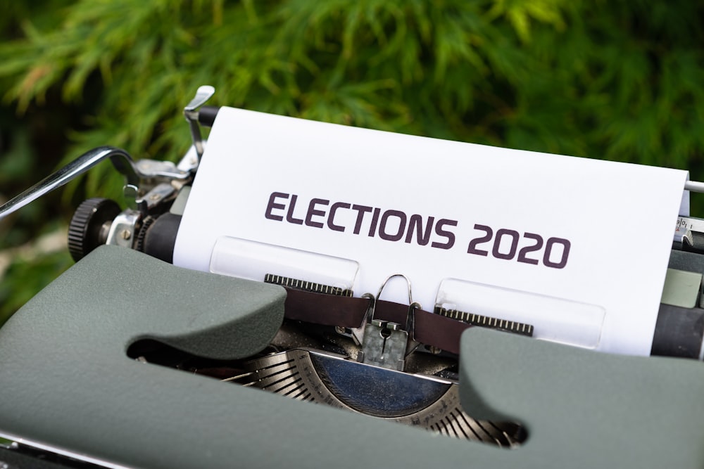 a close up of an old typewriter with a paper that reads election