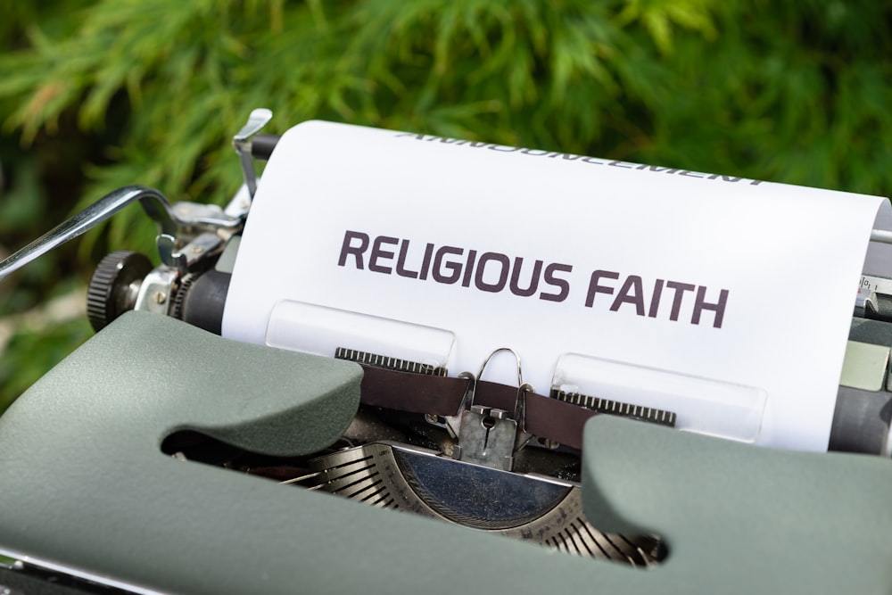 a close up of a typewriter with a religious faith paper on it