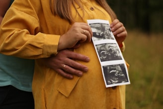 woman in brown coat holding picture of man in black shirt