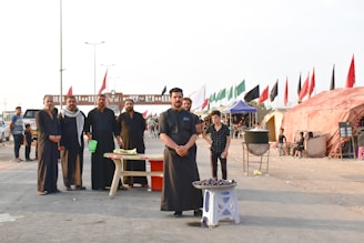 group of people standing near red and white canopy tent during daytime