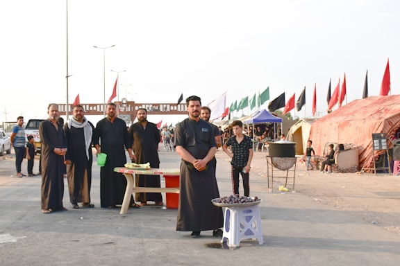 group of people standing near red and white canopy tent during daytime