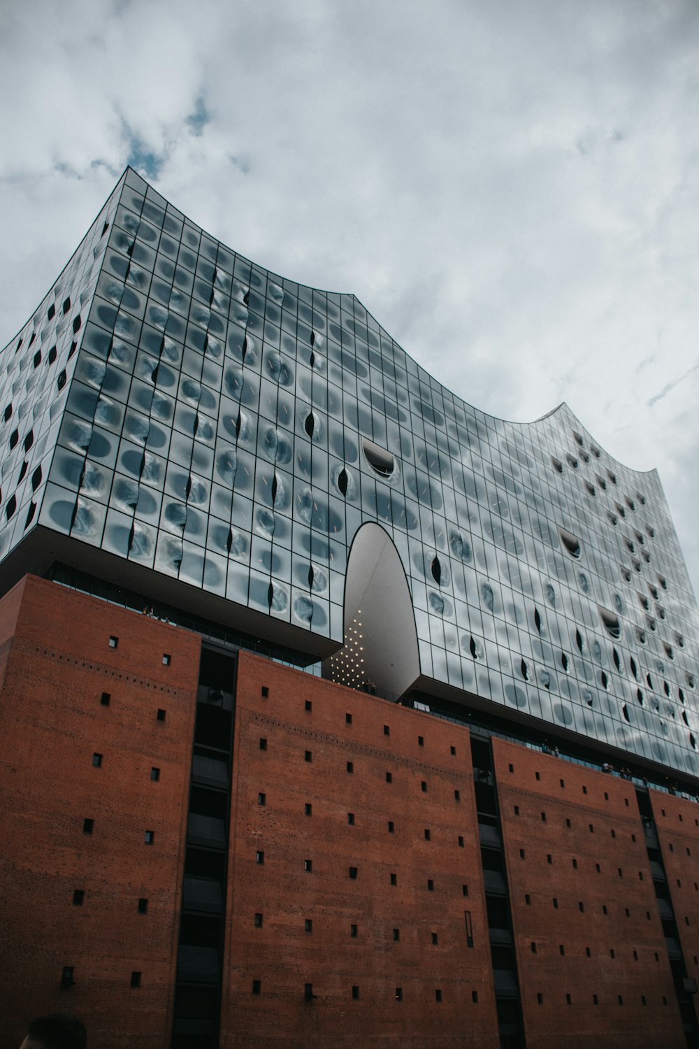 Edificio de hormigón marrón y gris bajo nubes blancas durante el día