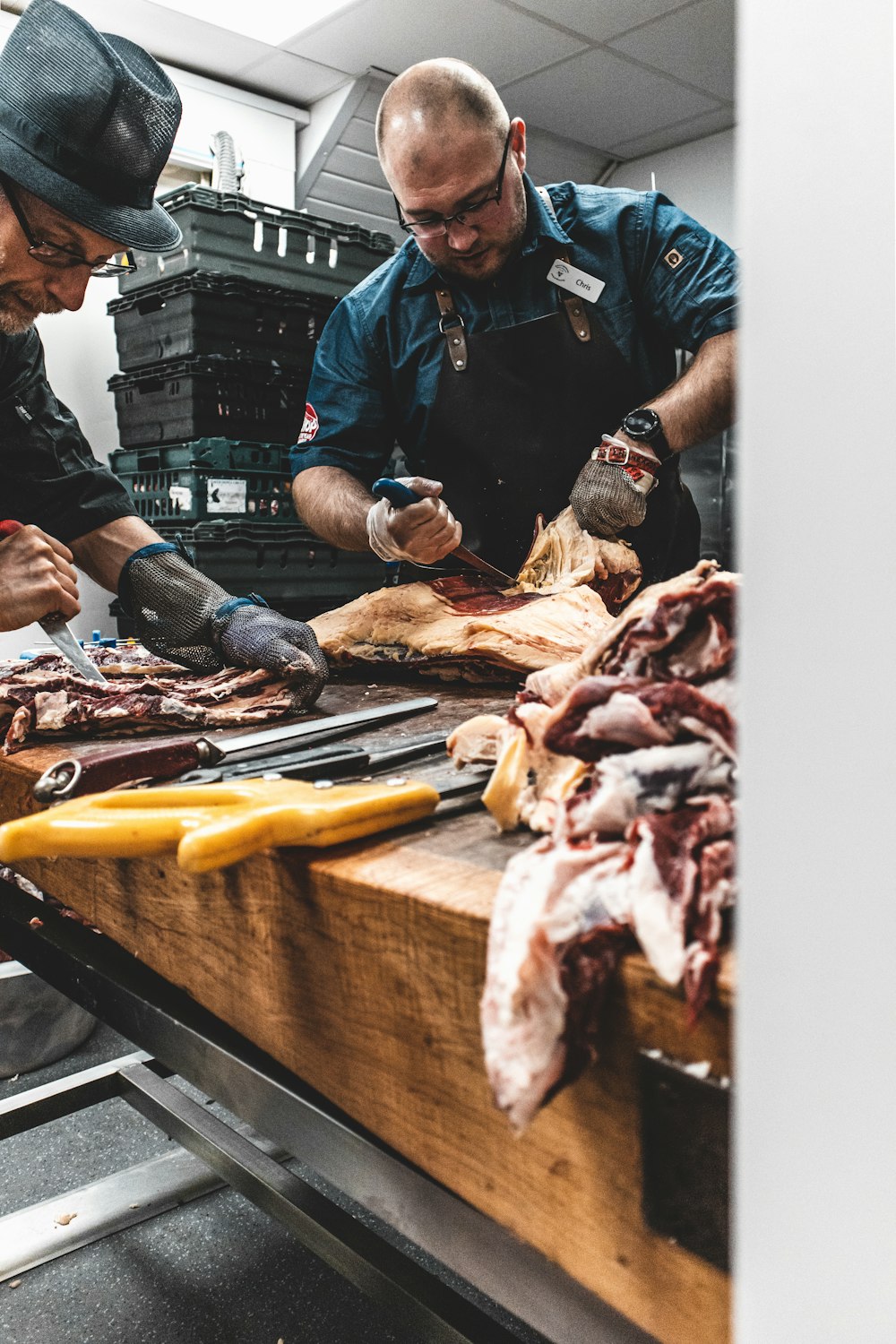 man in black polo shirt slicing meat on brown wooden chopping board