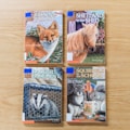 Four children's books are arranged on a wooden surface. Each book cover features an animal and text. The titles include a fox, a horse, a badger, and two squirrels, each illustrated in vibrant colors, emphasizing themes of nature and adventure.