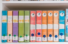 brown green and blue books on shelf