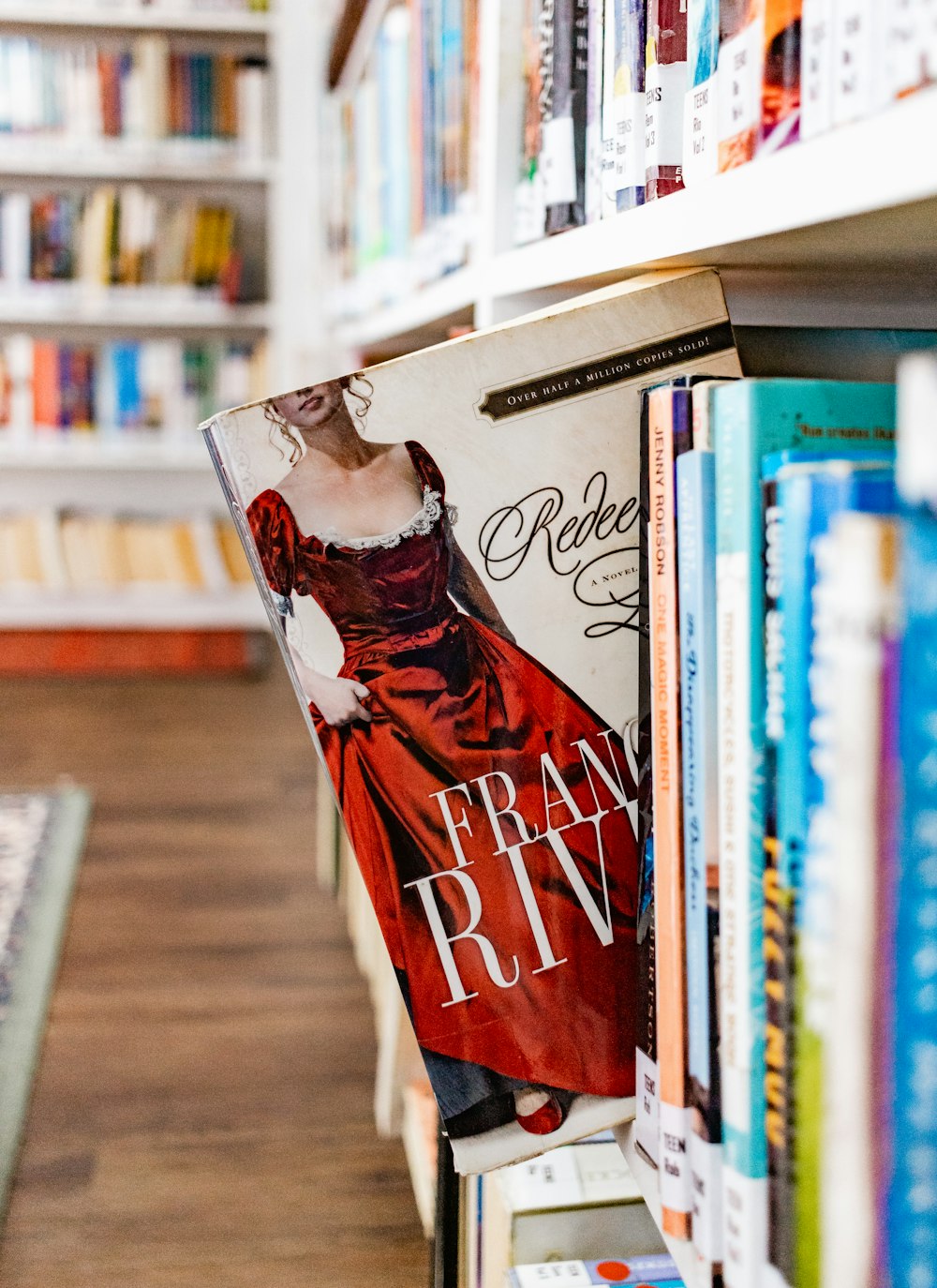 a bookshelf filled with lots of books and a woman in a red dress