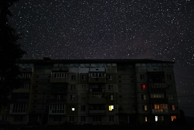 Evening shot of the apartment building glowing softly under the stars.