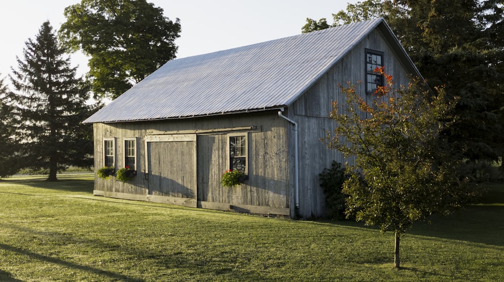 gray wooden house near green trees during daytime