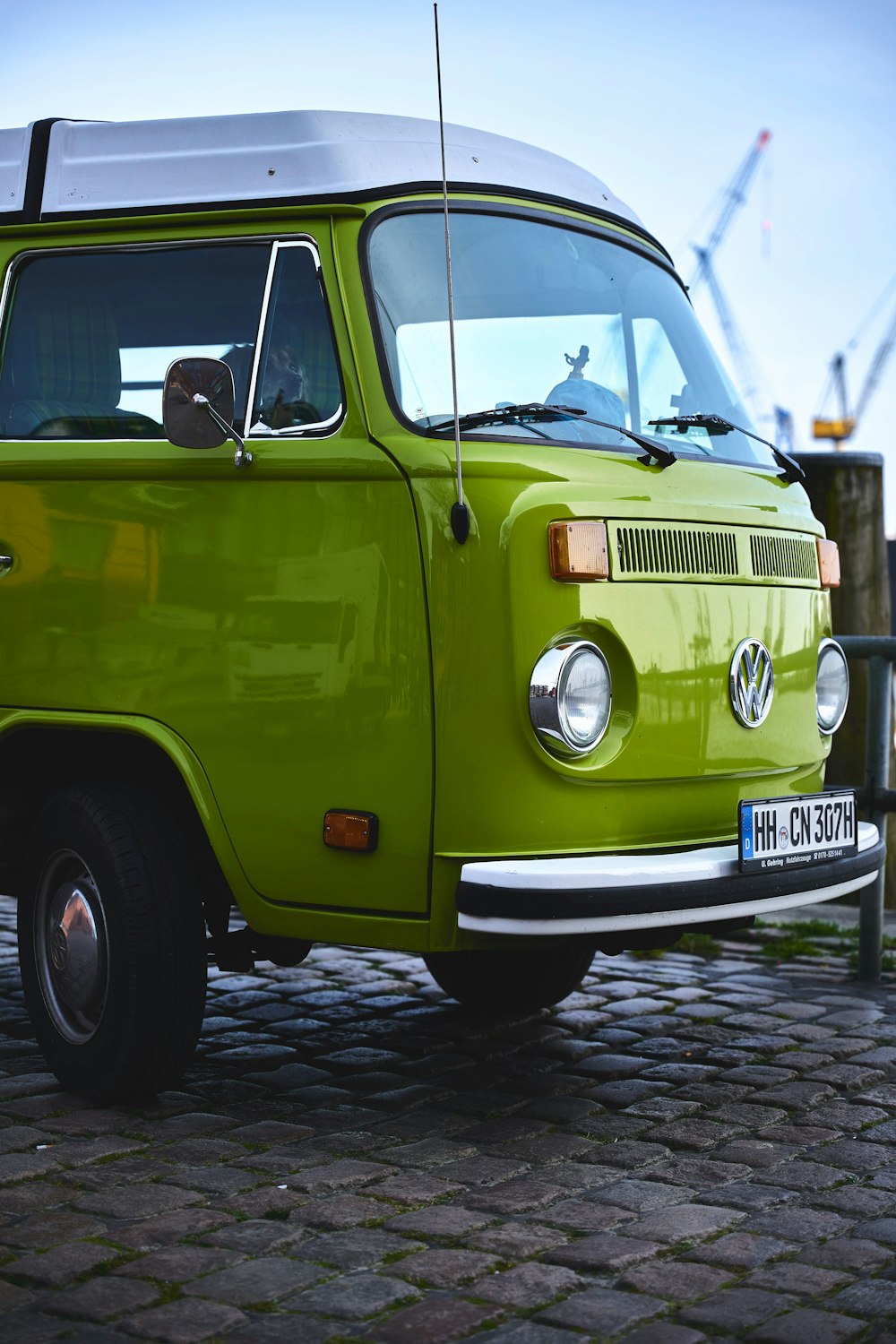 a green van parked on a cobblestone street