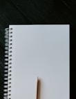 white spiral notebook on black wooden table