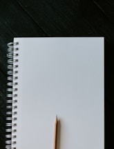 white spiral notebook on black wooden table