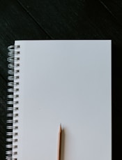 white spiral notebook on black wooden table