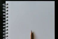 A blank page with a pencil resting on top, ready to start a new story.