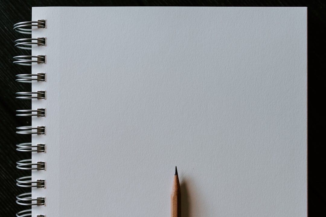 brown pencil on white surface, Wooden pencil on blank spiral notebook
