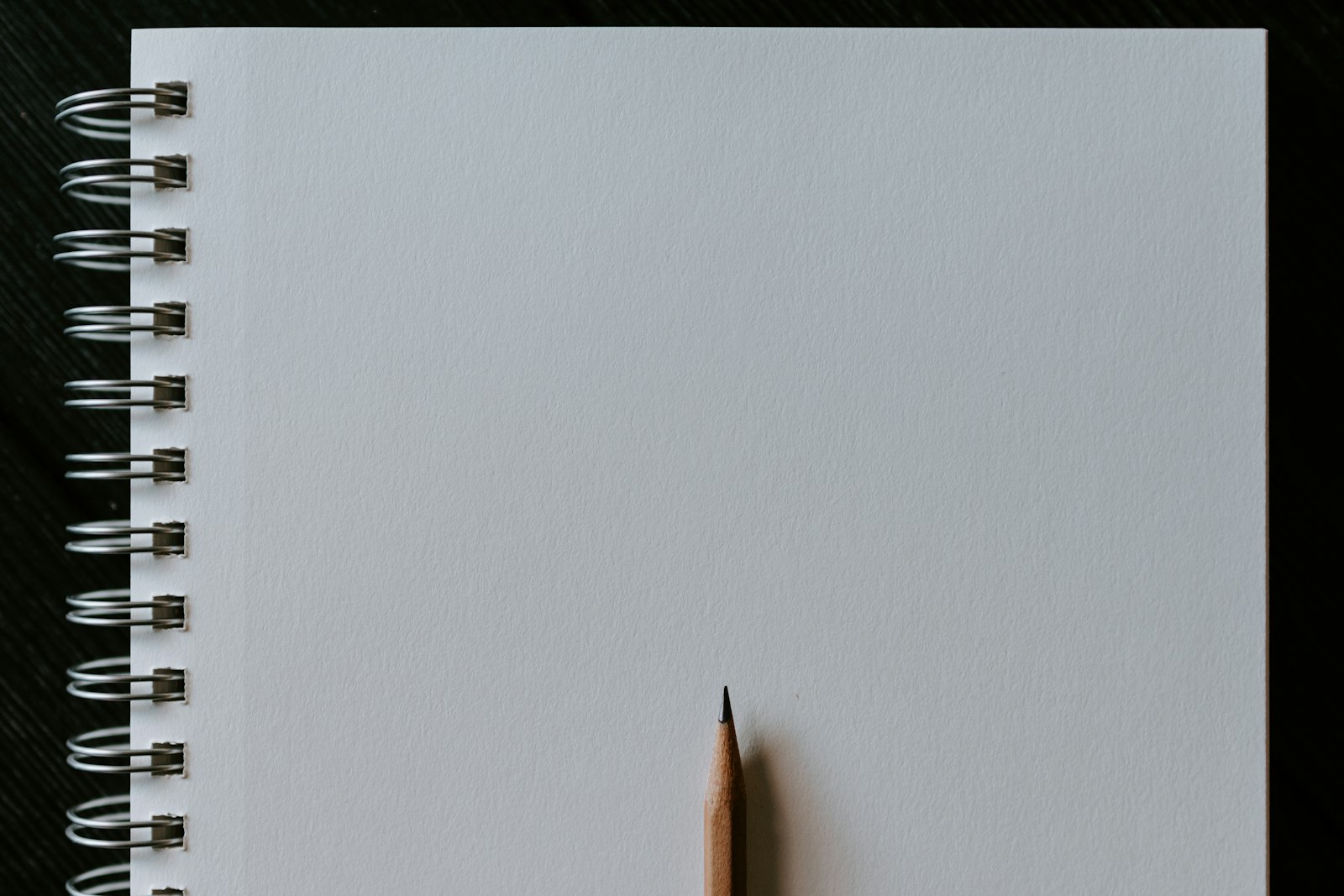 Un carnet à spirale vierge et la pointe d’un crayon