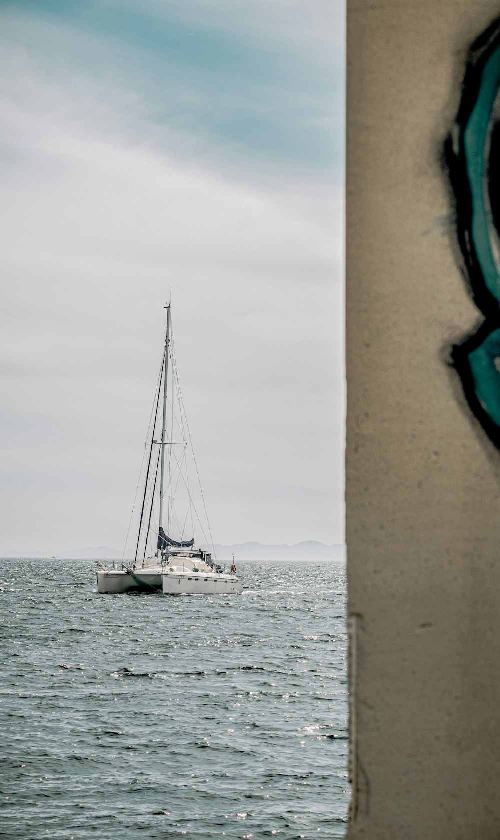 white sailboat on sea under white sky during daytime