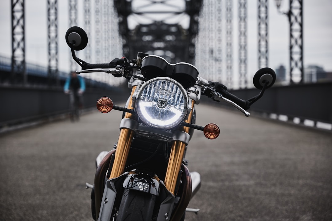 black and brown motorcycle parked on gray concrete road during daytime