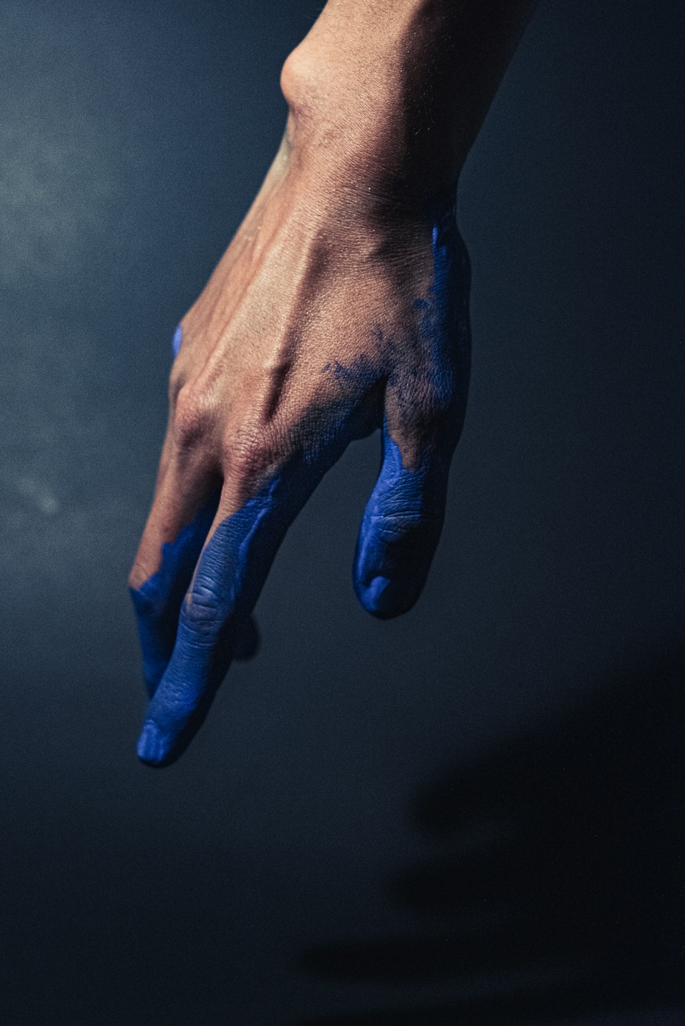 Mano izquierda de las personas con esmalte de uñas azul