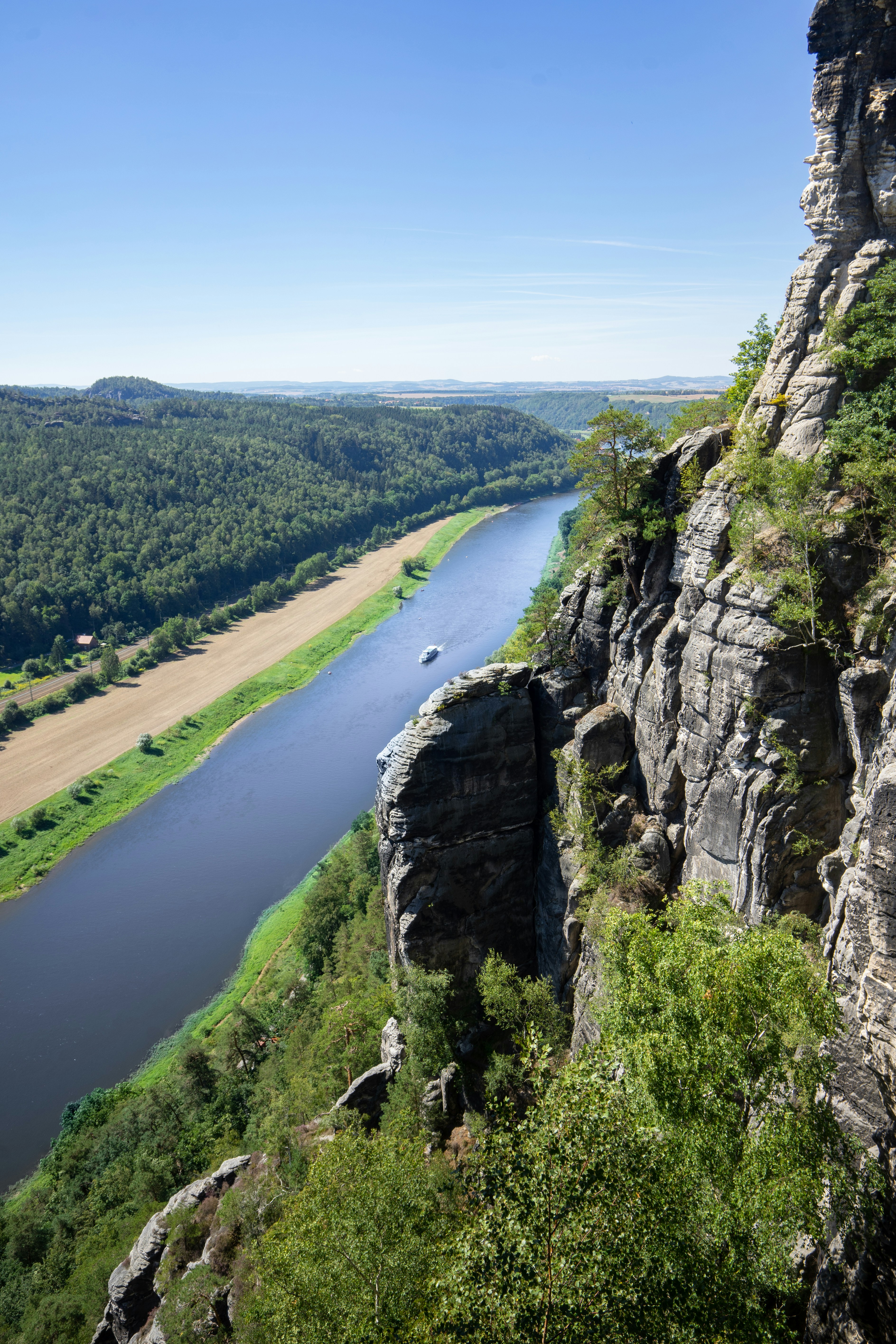 Fluss zwischen grünen Bäumen unter blauem Himmel tagsüber