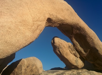 The iconic Pravčická brána sandstone arch towering against a clear blue sky.