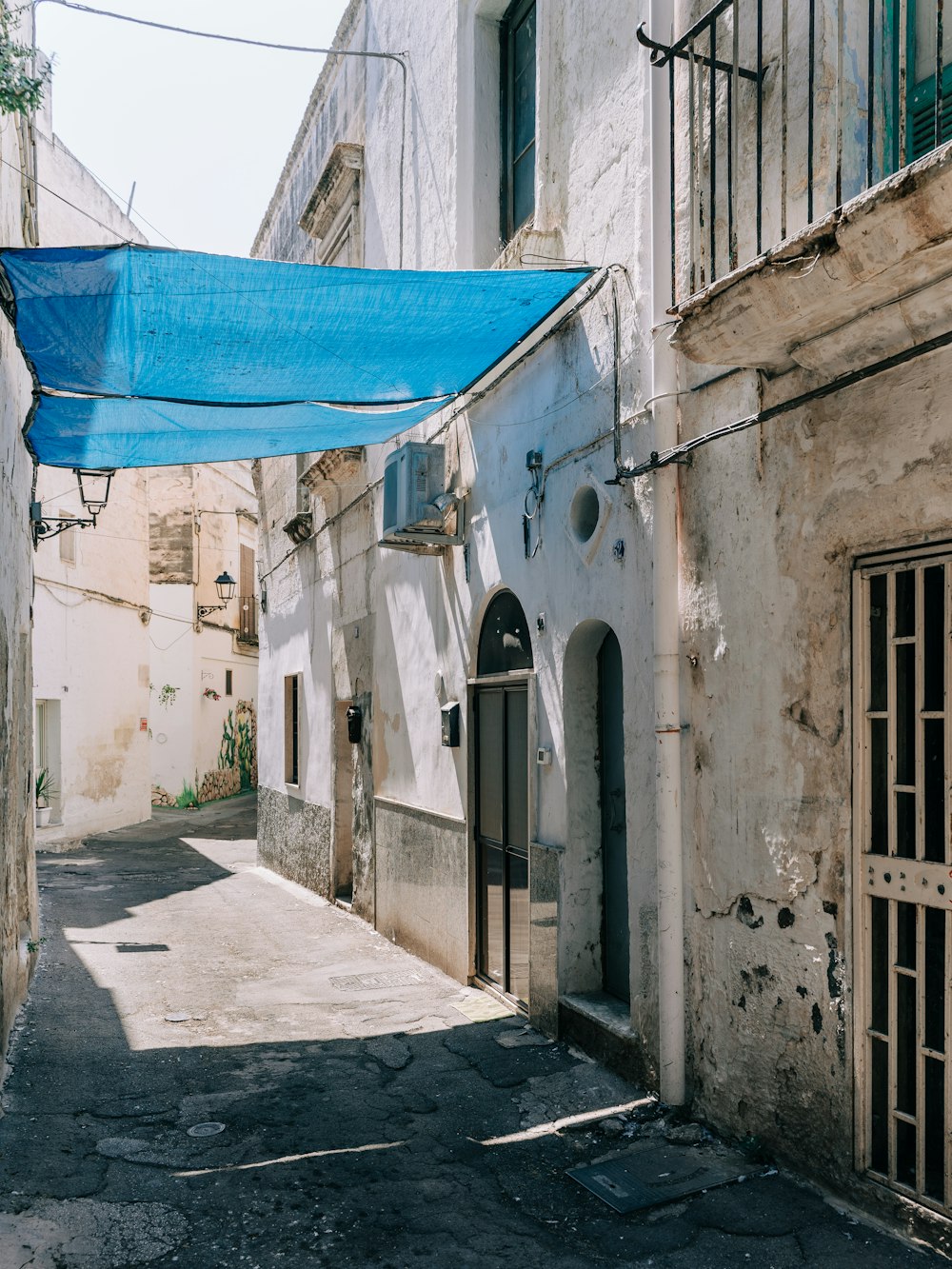 Textile bleu sur bâtiment en béton blanc pendant la journée