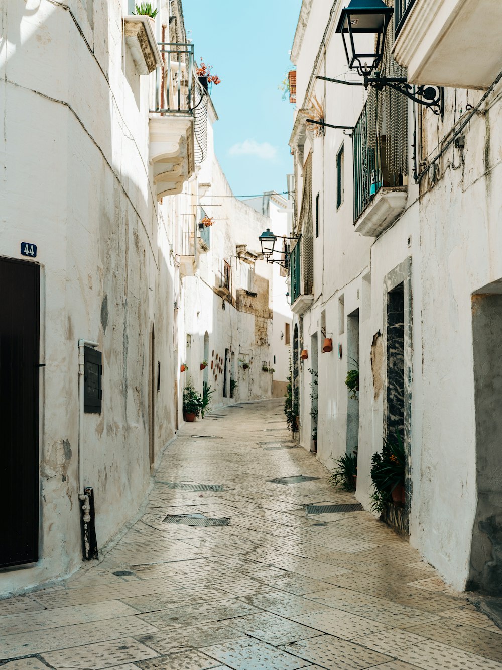 rua vazia entre edifícios de concreto branco durante o dia