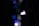 A single white LED bulb is lit against a dark background, surrounded by out-of-focus bokeh lights in various shades of blue and green.