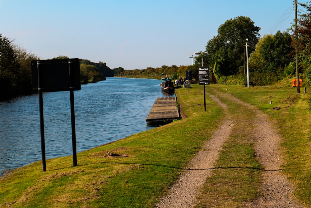 a dirt path next to a body of water