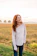 woman in white long sleeve shirt and blue denim jeans standing on green grass field during