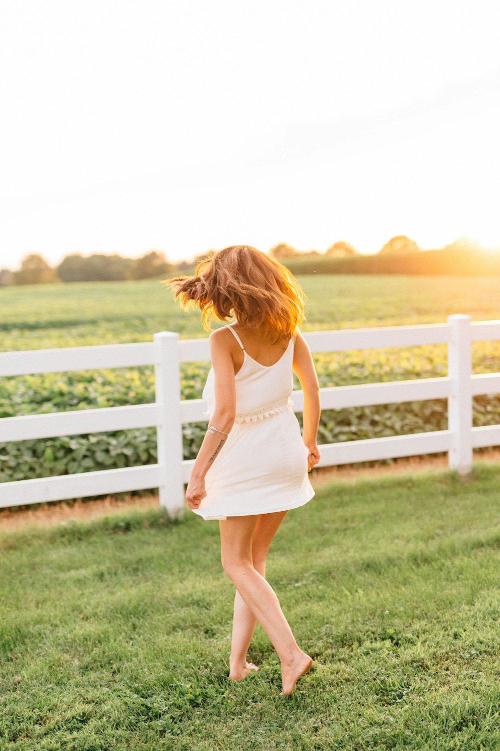 woman in white dress standing on green grass field during daytime