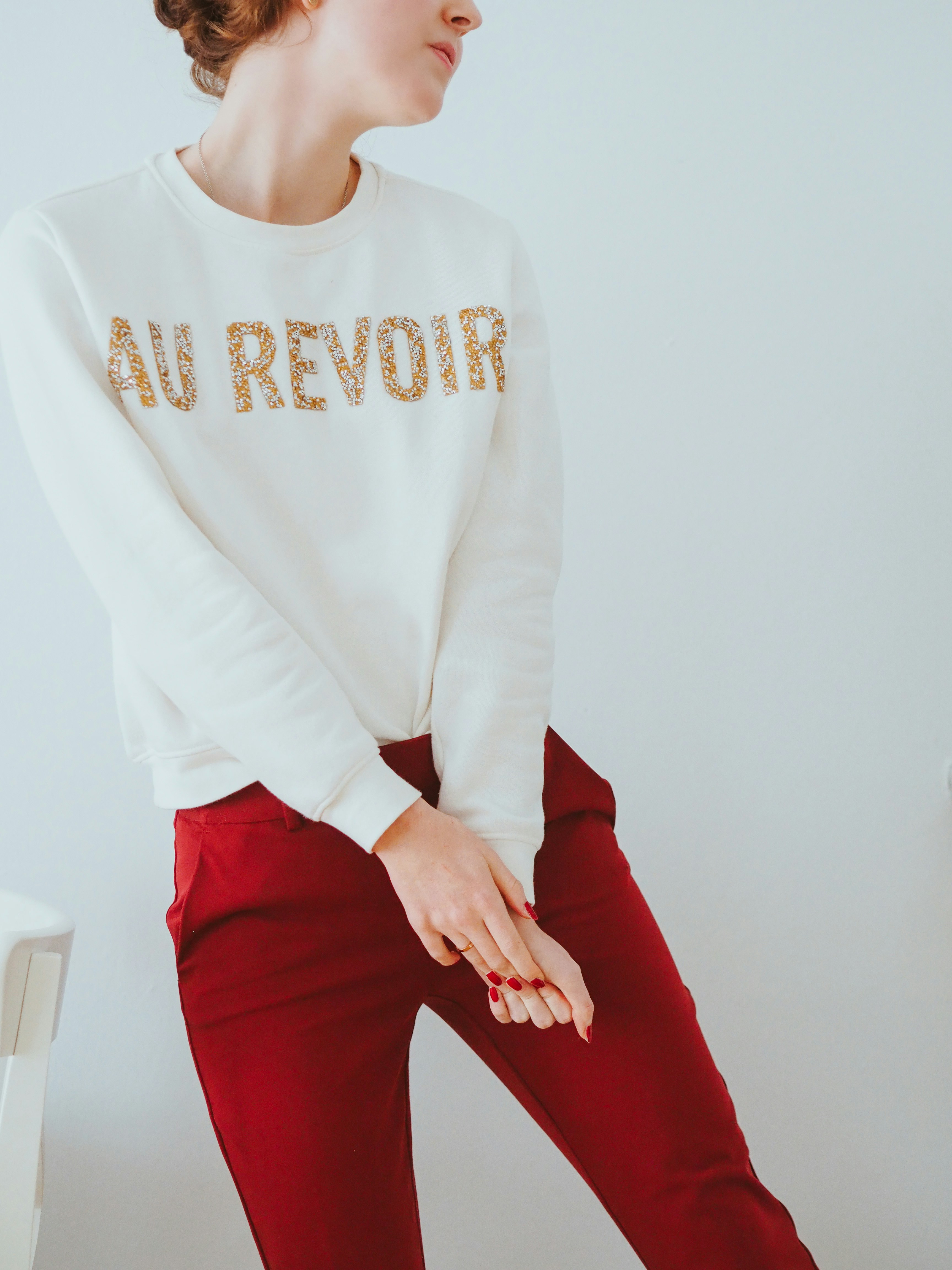 fille en chemise blanche à manches longues et pantalon rouge