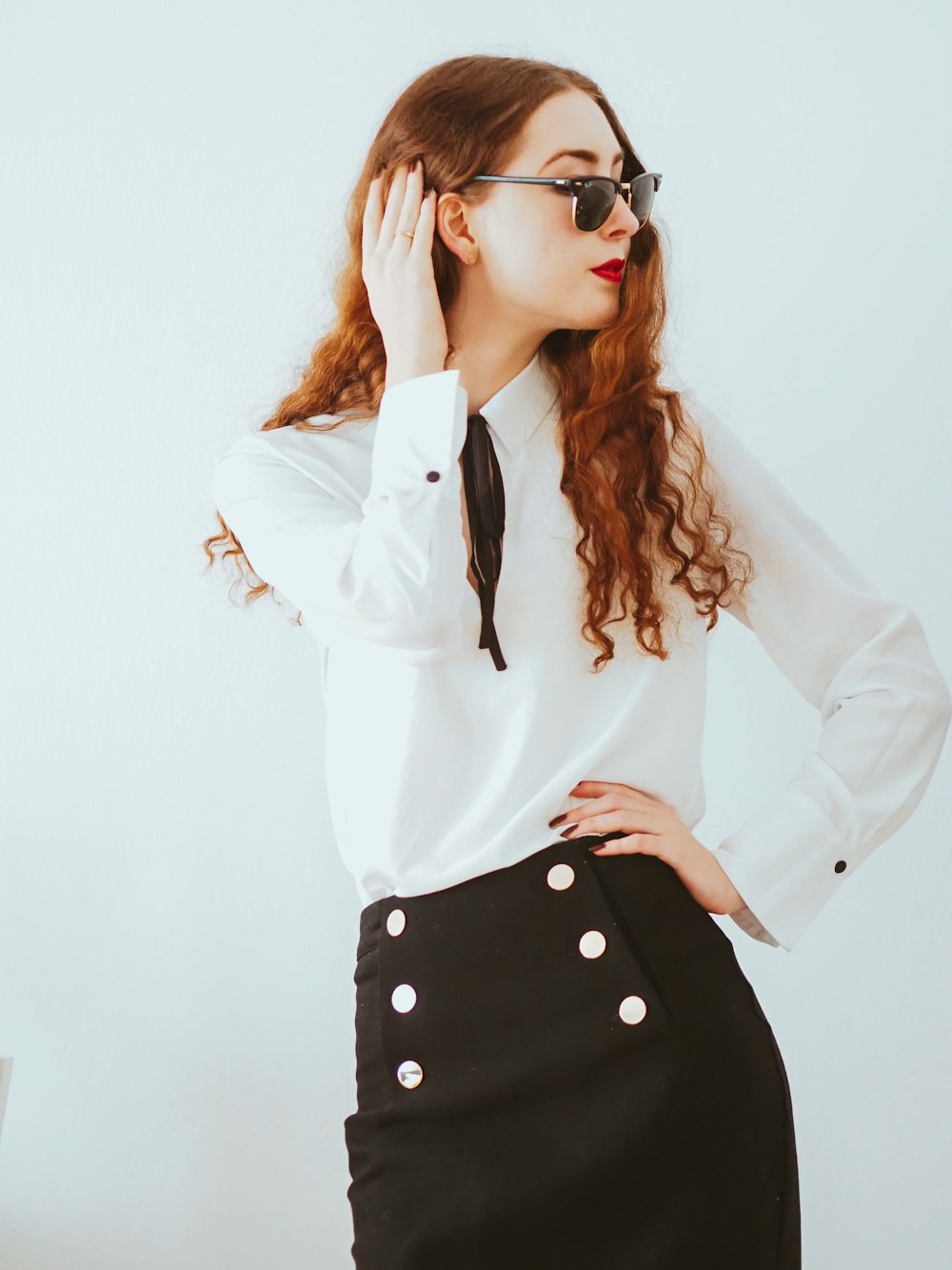 woman in white long sleeve shirt wearing black sunglasses