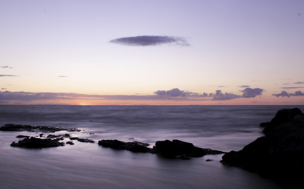 silhouette de rochers sur le rivage de la mer au coucher du soleil