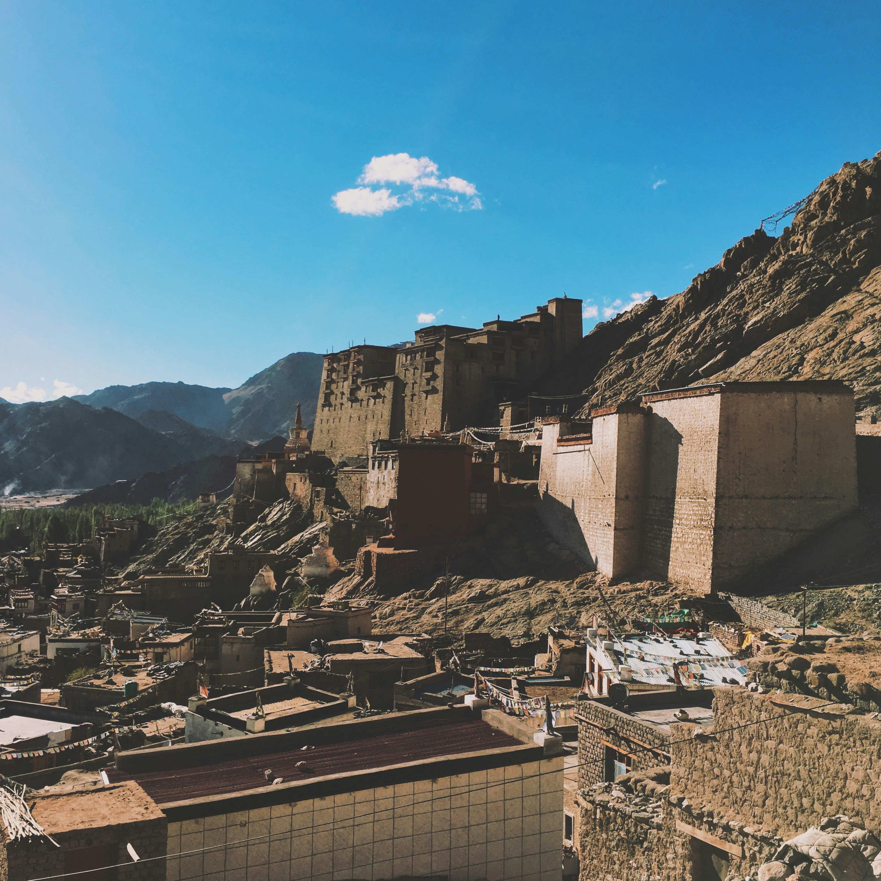 Ancient Buddhist monastery perched on rocky mountains in Spiti Valley under blue sky
