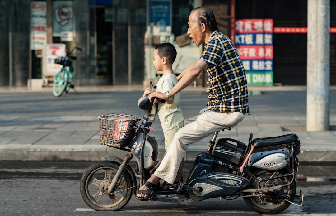 man in blue and white plaid shirt riding on black motorcycle