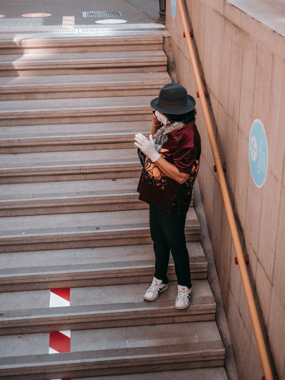 woman in black jacket and black pants standing on gray concrete stairs