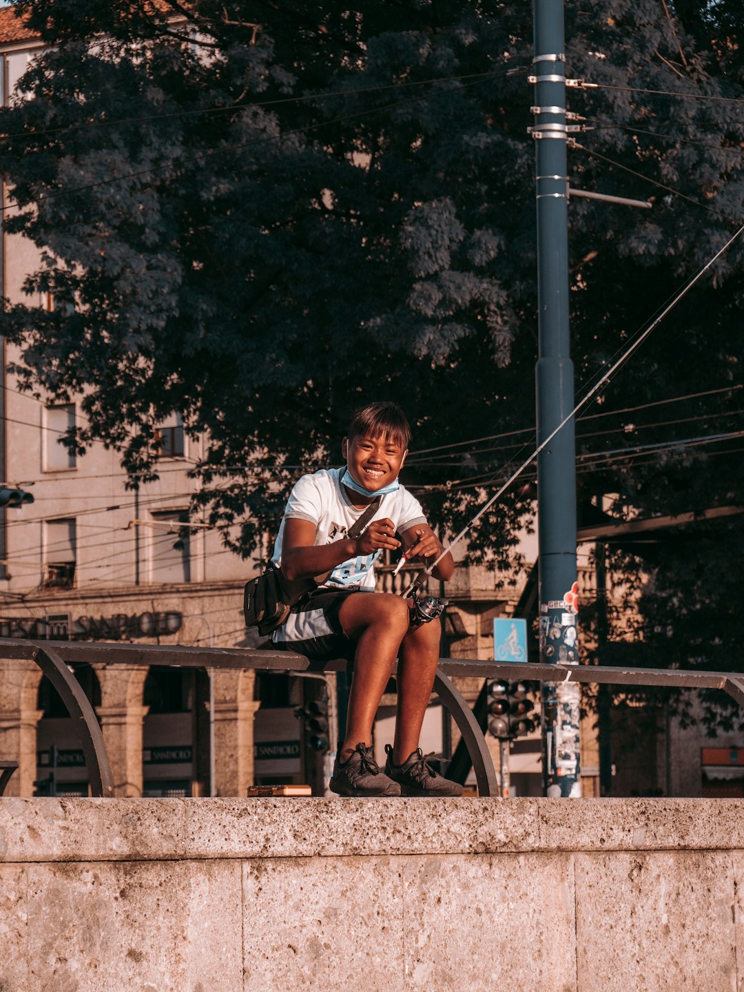 man in white and red shirt sitting on brown wooden bench