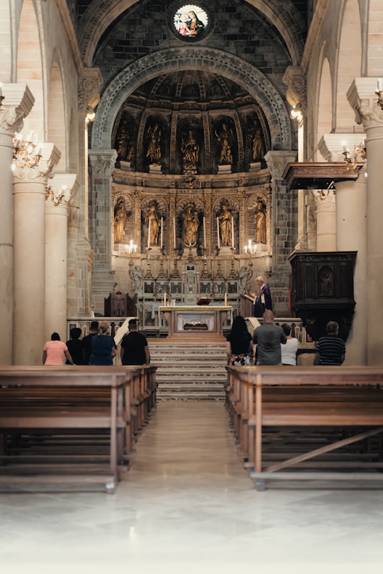 people sitting on brown wooden bench inside cathedral in Avetrana Italy