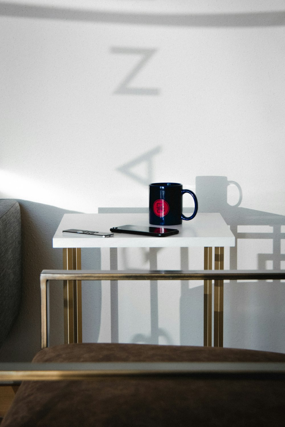 Taza de cerámica negra y roja sobre mesa de madera blanca