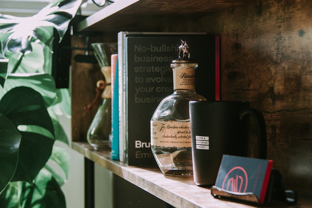 black ceramic mug beside clear glass bottle