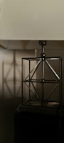 Handmade metal table lamp featuring a simple geometric shape and brushed steel surface.