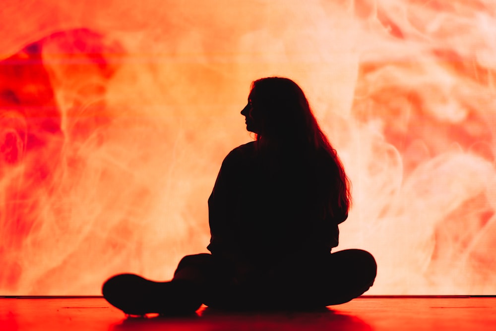 silhouette of woman sitting on floor