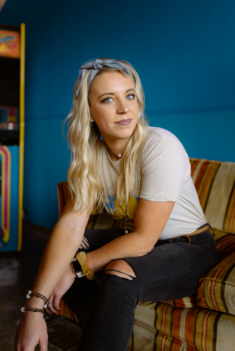 woman in white crew neck t-shirt and blue denim jeans sitting on brown wooden table