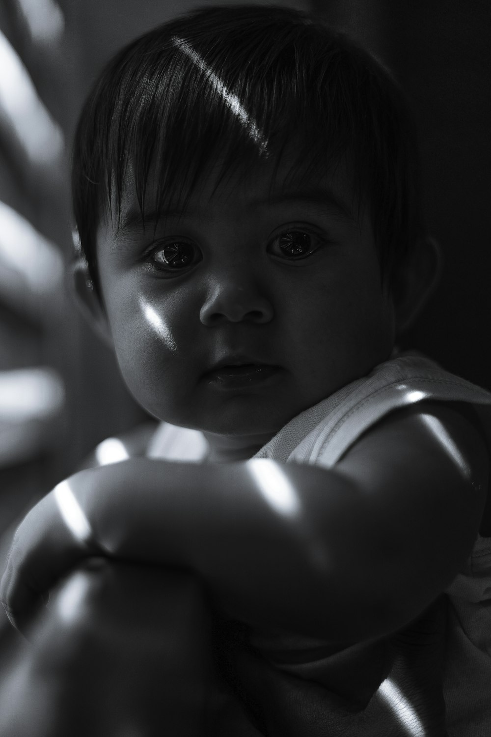 grayscale photo of baby in white shirt