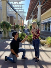 man in black crew neck t-shirt and blue denim jeans holding woman in red and