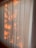 Vertical blinds partially illuminated by warm sunlight, casting soft, natural patterns and shadows across the surface.