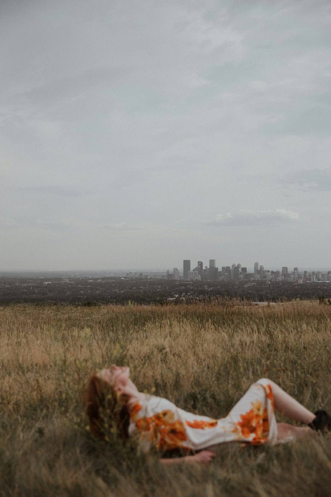 woman in white dress lying on green grass field during daytime